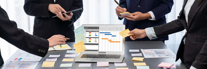 Analyst team use sticky note for creative and analytic brainstorm for business idea with BI data dashboard on laptop screen. Analysis financial data visualization tech for marketing strategy. Prodigy