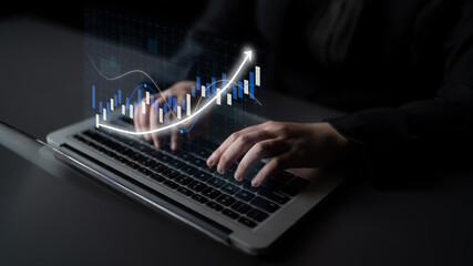 A professional typing on a laptop keyboard with a digital graph overlay representing business growth, showcasing modern technology in a corporate setting. Impute