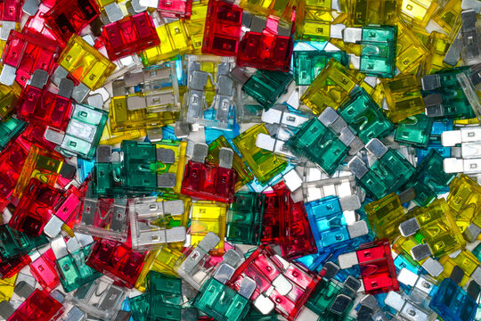 Colorful automotive blade fuses background, assorted standard car fuses flat lay