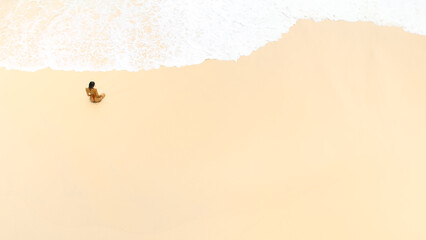 Minimal Aerial View Of Woman Sitting On Sandy Bali Beach By Waves