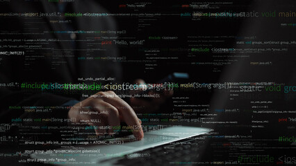 A focused image of hands typing on a laptop keyboard surrounded by streams of code and text, illustrating modern programming and technology in a dark environment. Xenic