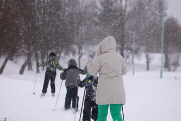 mother and children skiing in snowy weather