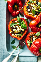 Peppers stuffed with minced meat, rice and vegetables. Topped with herbs and feta cheese in a ceramic dish