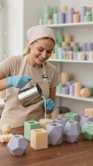 Smiling woman making handmade candles in her workshop. Vertical photo of young artisan pouring melted wax into pastel geometric molds. Small business and creative hobby concept
