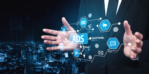A businessman is showcasing a digital ads concept with social media icons and network connections, set against a futuristic urban skyline at night. Tessel