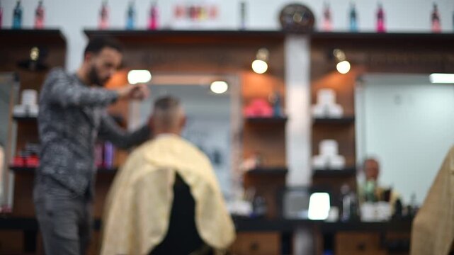Blurred view of a barber cutting a client's hair inside a modern barbershop