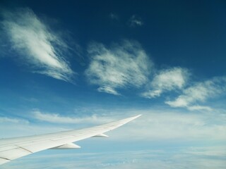 Fototapeta premium Airplane Wing Above Summer Clouds During Transpacific Flight