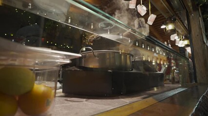 Traditional wooden stall selling hot Gluehwein at the Marienplatz Christmas market in Munich. People gathering to enjoy mulled wine in the historic city center during a festive winter night