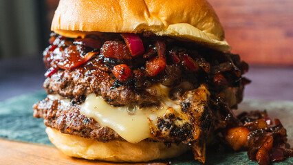 Burger topped with rich bacon jam, melted cheese, and red onion. Sweet, savory, and smoky flavors combined in one delicious gourmet sandwich. Perfect for indulgent comfort food.