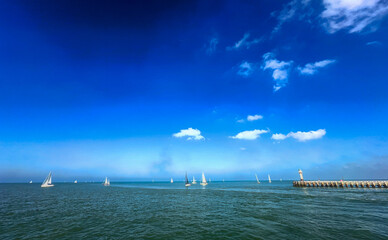 A serene view of sailboats on calm waters under a clear blue sky, perfect for travel and adventure themes.
