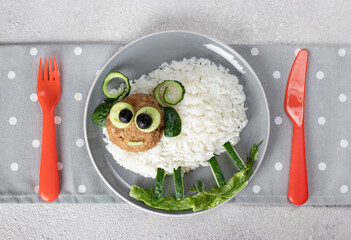 Creative breakfast for a child - rice, cutlet, cucumber and olives in the shape of cute sheep