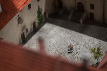 Detail of a model figurine of a woman carrying buckets of water on a waterfront.
