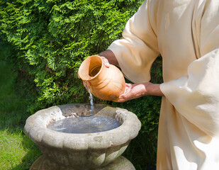 Hands pour water into the pot