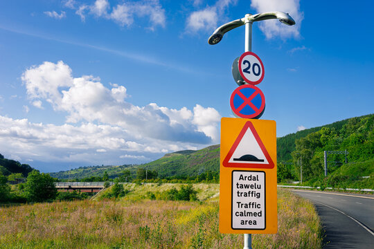 Multiple British street signs with bilingual Welsh and English text on a sunny day in the South Wales Valleys