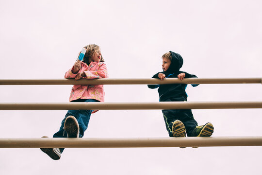 Kids on railing with popsicles 