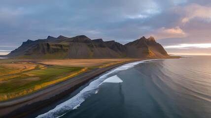 Aerial view of rugged icelandic coastline with majestic mountains meeting the ocean at sunrise with landscape and travel and tourism and nature