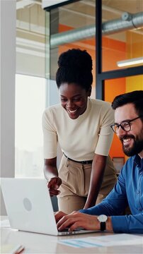 Smiling colleagues collaborating on laptop in vibrant office background vertical teamwork success innovation business partnership technology workspace professional happy diverse inclusive modern desig
