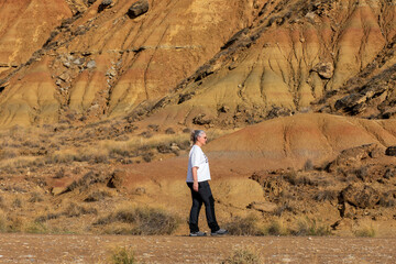 Walking amidst stunning golden hills and rugged terrain in a serene landscape at sunset