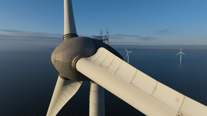 Aerial view of a wind turbine's massive blades slicing through the calm sea air, Noordoostpolder, Noordoostpolder, Netherlands.