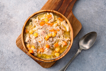 Delicious chicken soup with chickpeas served on an old stone table.