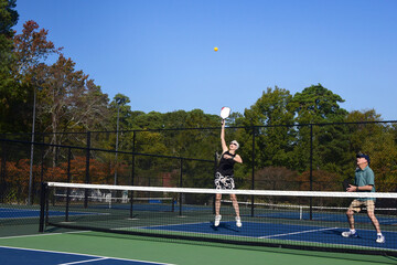 Ball Flies Past Jumping Pickle Ball Player