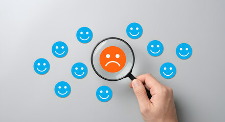 magnifying glass on sad face among happy faces