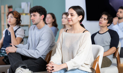 Young people are listening to lecture in auditorium, students listen to teacher. Personal growth...