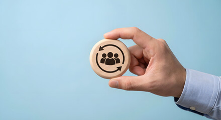 hand holding wooden token with people icon and cycle