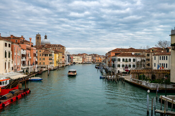 Obraz premium Characteristic historic buildings and a vaporetto navigating the