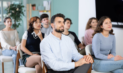 Young people are listening to lecture in auditorium, students listen to teacher. Personal growth...