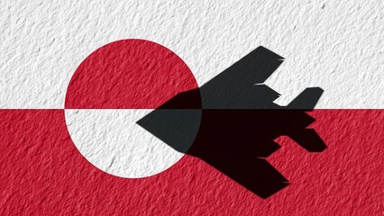 Shadow of a military fighter jet projected onto the snowy flag of Greenland.