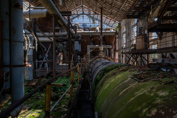 Fototapeta premium Derelict industrial hall of an abandoned Italian sugar mill. Large warehouse ruins with decaying walls and urban exploration atmosphere
