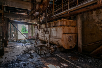Fototapeta premium Derelict industrial hall of an abandoned Italian sugar mill. Large warehouse ruins with decaying walls and urban exploration atmosphere
