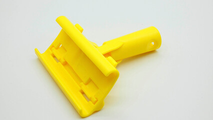 Yellow tool used for cleaning surfaces in various tasks indoors or outdoors in everyday activities around the home or workshop setting