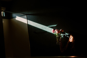 Woman holding flowers with light beam