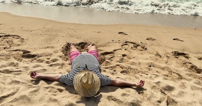 A vacation by the sea or ocean in a tropical country. A drunk man sleeps on the beach. Man sleeping on the ocean shore. Man sleeping on the beach on the ocean shore.  Slow motion