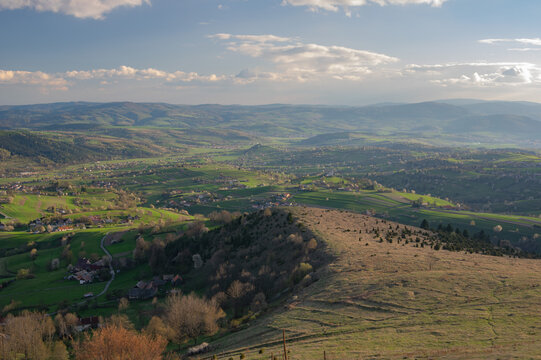 Aerial view of the rolling hills and valleys, with patches of green and brown under a soft, diffused sunlight, Javorinka, Hrinova, Banska Bystrica Region, Slovakia.