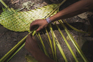 The hands of a man seen from above, making a design with the palms destined for Palm Sunday, in the city of Caracas, Venezuela