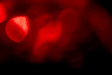 A blurry red image with a red light in the center. The light is surrounded by red and orange colors. Abstract light leaks for design and special effects.