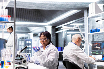 Obraz premium African american researcher examining Petri dish in a biolab. Observation of matter, microorganisms and cellular growth reflects experimental science and pathology investigation.