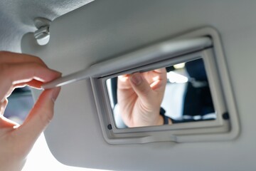 車のサンバイザーに付いた鏡のクローズアップ。