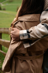 Couple embracing outdoors in autumn, feeling warmth and connection on a cool day