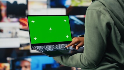 Green screen mockup laptop used by person to get access to video recommendations delivered instantly. User in digital era enabling unlimited streaming looking at clips on chroma key notebook