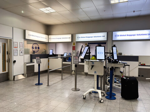 Global baggage solutions check in area at Manchester airport UK with modern counters and screens