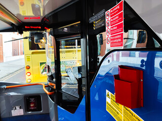Bus interior in Manchester street scene with safety signs, reflections, and urban transit highlights