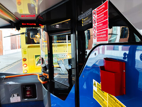 Bus interior in Manchester street scene with safety signs, reflections, and urban transit highlights