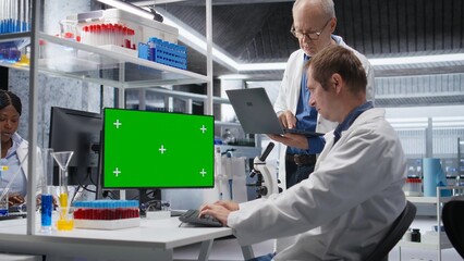 Green screen on computer display with colleagues working in biotechnology lab, using laboratory analysis, bioengineering and healthcare technology. Progress in pharmaceutical science.