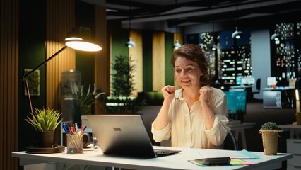Surprised woman receiving a contract deal offer and feeling satisfied, working after hours for a career breakthrough. Business manager smiling in excitement for an amazing opportunity. Camera A.