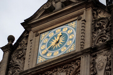 Beautiful blue clock with gold elements on the roof of the building.