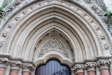 Wesley Memorial Church, a Methodist church in central Oxford. Tympanum above the entrance, decorated with stone carvings. Oxford, United Kingdom.
